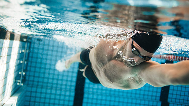 Mann schwimmt Kraultechnik
